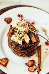 Chocolate pancakes with banana, peanut butter, green buckwheat and strawberries. Gluten-free fried sweet breakfast, vegan dessert.Copy space.