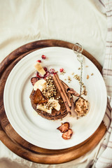 Chocolate pancakes with banana, peanut butter, green buckwheat and strawberries. Gluten-free fried sweet breakfast, vegan dessert.Copy space.