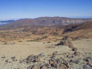 desert volcanic landscape on Tenerife with purple mountains in el teide national nature park with Huevos del Teide (Eggs of Teide) lava balls rocks, clear blue sky background
