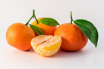 Whole tangerines or mandarines orange fruits and peeled segments isolated on white background