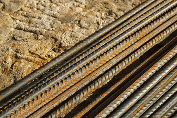 Background with bunch of rusty metal bars over a Travertine stone pavement