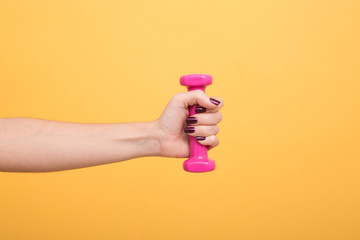 A woman hand holding a pink dumbbell