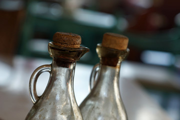 Necks of 2 old bottles of oil on the table in the restaurant, with cork caps