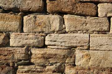 Texture background of old natural stone brick wall in yellow with joint and rough surface, Old Bazar in Skopje