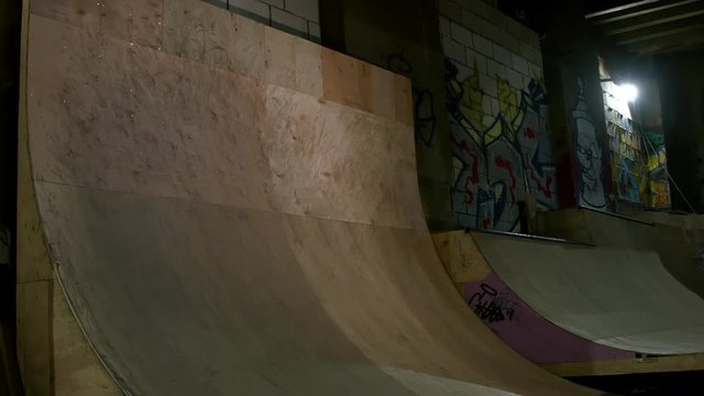 Extreme Sport BMX Athlete Doing Tricks in a Wooden Skateboard Park with Dynamic Lighting in underground, indastrial background