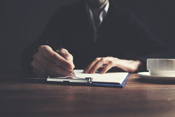 businessman hand document and coffee on table