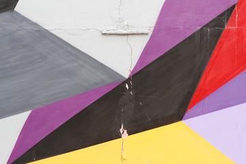 Colorful (grey, purple, yellow, red and black) painted wall with cracks as background or texture