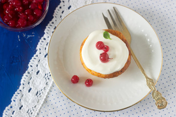 Mini cheesecake with whipped cream and red currant. Rustic style.