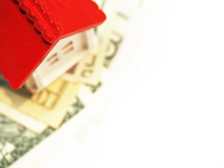 Fototapeta na wymiar Invest in real estate, mortgage concept, little home. White house with a red roof on dollar bills, dollars banknotes isolated on white background, top view