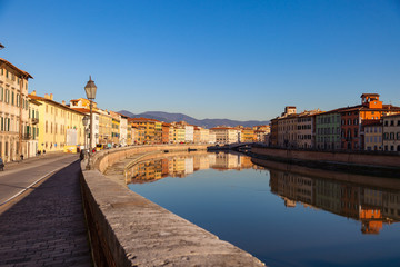 Arno river embankment with colorful old houses and Ponte di Mezzo . Picturesque medieval town of Pisa, Tuscany, Italy.