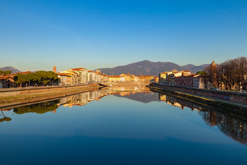 Fototapeta premium Arno river embankment with colorful old houses, view from Ponte della Citadella. Picturesque medieval town of Pisa, Tuscany, Italy.