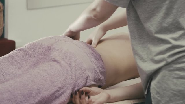 Massage procedure of female back in spa. Masseur massaging back of girl. Healthy lifestyle