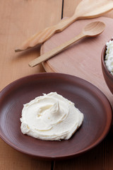 Cheese, cottage cheese and cream in clay ware, fresh curd on a wooden background, rustic sour cream, brown shade, healthy food, French breakfast, top view, goat curd, protein