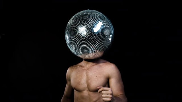 cool muscular man in silver costume with a mirror ball for a head. perfect video for fashion, style, disco, clubs and events