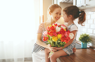 Fototapeta na wymiar happy mother's day! child daughter gives mother a bouquet of flowers to tulips.