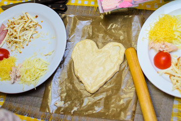 children cook pizza from raw ingredients with their own hands