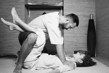 The massage therapist makes a Tibetan massage to a young woman. man and woman in white doing gymnastics