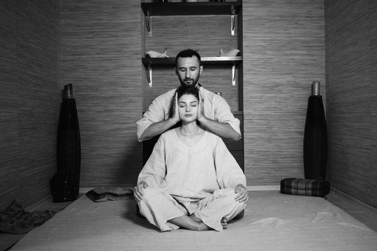 man and woman in white sitting in the lotus position and relax. Tibetan massage. Health. meditation