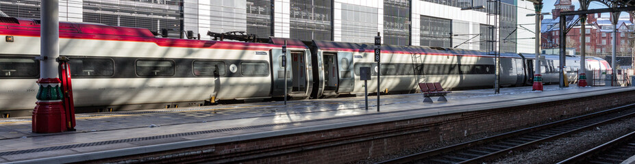 A high speed passenger train stands at the station in the winter sunshine