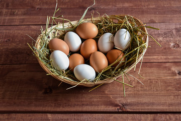 Different eggs are white, brown in a basket for Easter