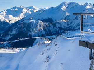 Gondola lift cabin of ski-lift in the ski resort in the early morning at dawn with mountain peak in the distance. Winter snowboard and skiing concept. France, Courchevel, 2018