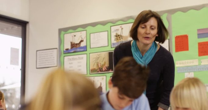 4k, Young teacher educating a group of elementary children. Slow motion.