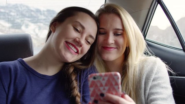 Happy Young Women Take A Selfie Together, Then Look At It, In Back Seat Of Moving Car - Shot On Red Scarlet-W Dragon In 4k/Slow Motion