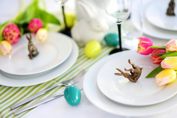 Beautiful table setting with crockery and flowers for Easter celebration