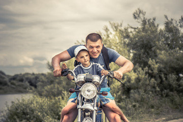 Joyful father biker son riding motorcycle lifestyle portrait concept happy paternity 