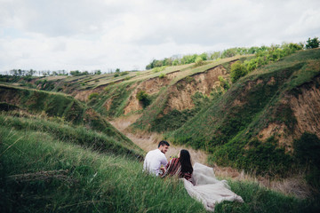 Obraz premium Happy newlyweds have fun lying on the lawn outside