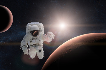 Astronaut in outer space on background of the Mars. Elements of this image furnished by NASA.
