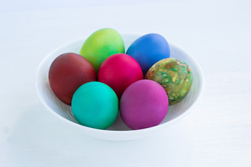 Fototapeta na wymiar White plate of Easter multicolored boiled eggs decoration
