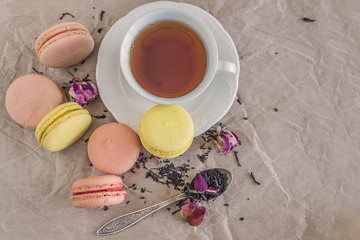 Tea time with french macaroons and rose flowers