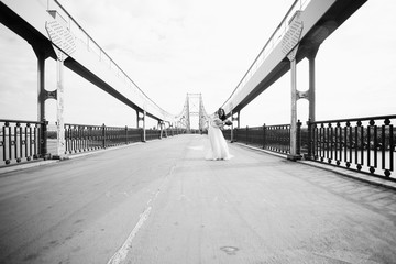 The bride with ball walking along bridge