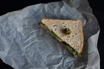 Sandwich with cheese, ham and olive. Lunch time. Club sandwich on the black background.