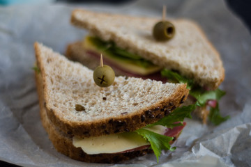 Sandwich with cheese, ham and olive. Lunch time. Club sandwich on the black background.