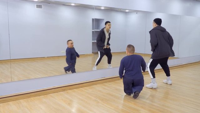 A lot of people dances in front of the mirror in light studio