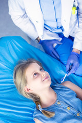 Little girl sitting in the dentists office