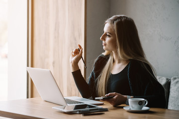 Young beautiful girl preparing for exams with laptop, surfing articles about innovations in web development, programming and design. Business lady working through internet in digital marketing field.