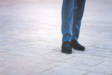 low section of a business man standing on a textured floor
