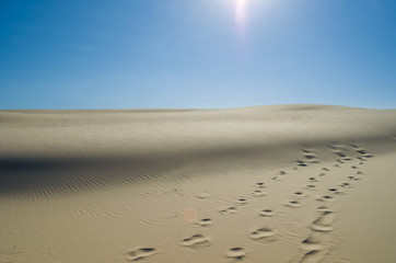 Sand dunes with blue sky and sun