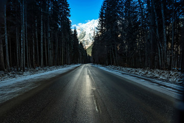 Obraz premium Road through winter mountain forest