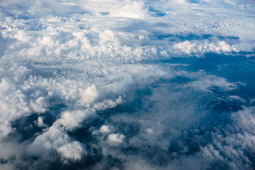 Obraz na płótnie Canvas Above heaven, view from airplane to fluffy white clouds and blue atmosphere, nature skyline landscape