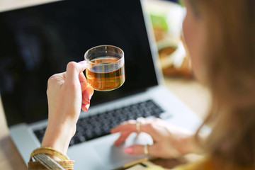 Young woman on a coffee break or enjoying the coffee-break, Using laptop computer