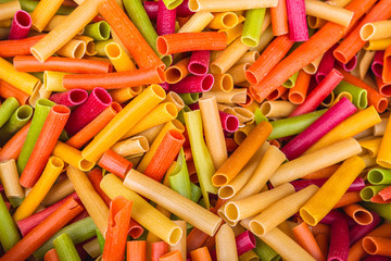 Food background - uncooked colored wheat pasta