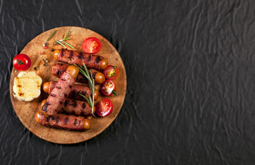 Festive cocktail sausages wrapped in crispy smoked bacon commonly known as 'Pigs in Blankets' on black background