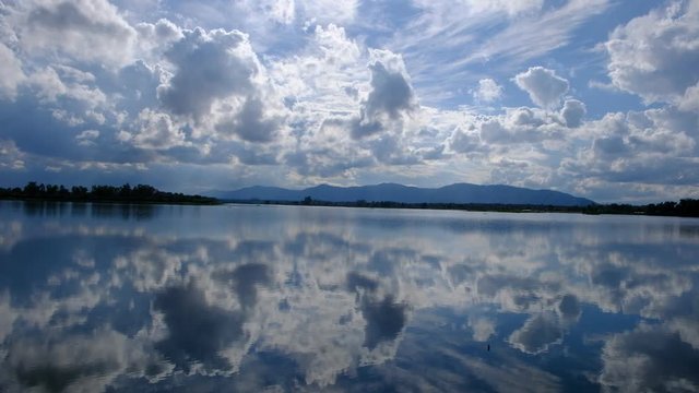The lake has a reflection of the clouds and the sky. 