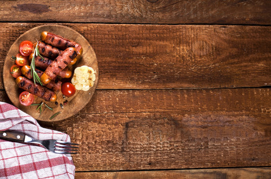 Festive cocktail sausages wrapped in crispy smoked bacon commonly known as 'Pigs in Blankets' on wooden background