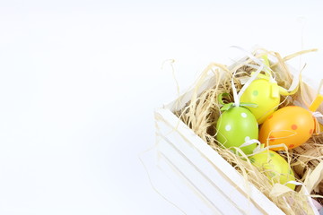 Wielkanoc - Kolorowe pisanki i biała, drewniana skrzynia - białe tło