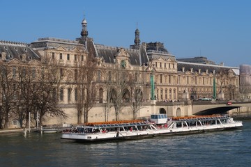 Paris, Palais du Louvre avec un bateau mouche sur la Seine (France)